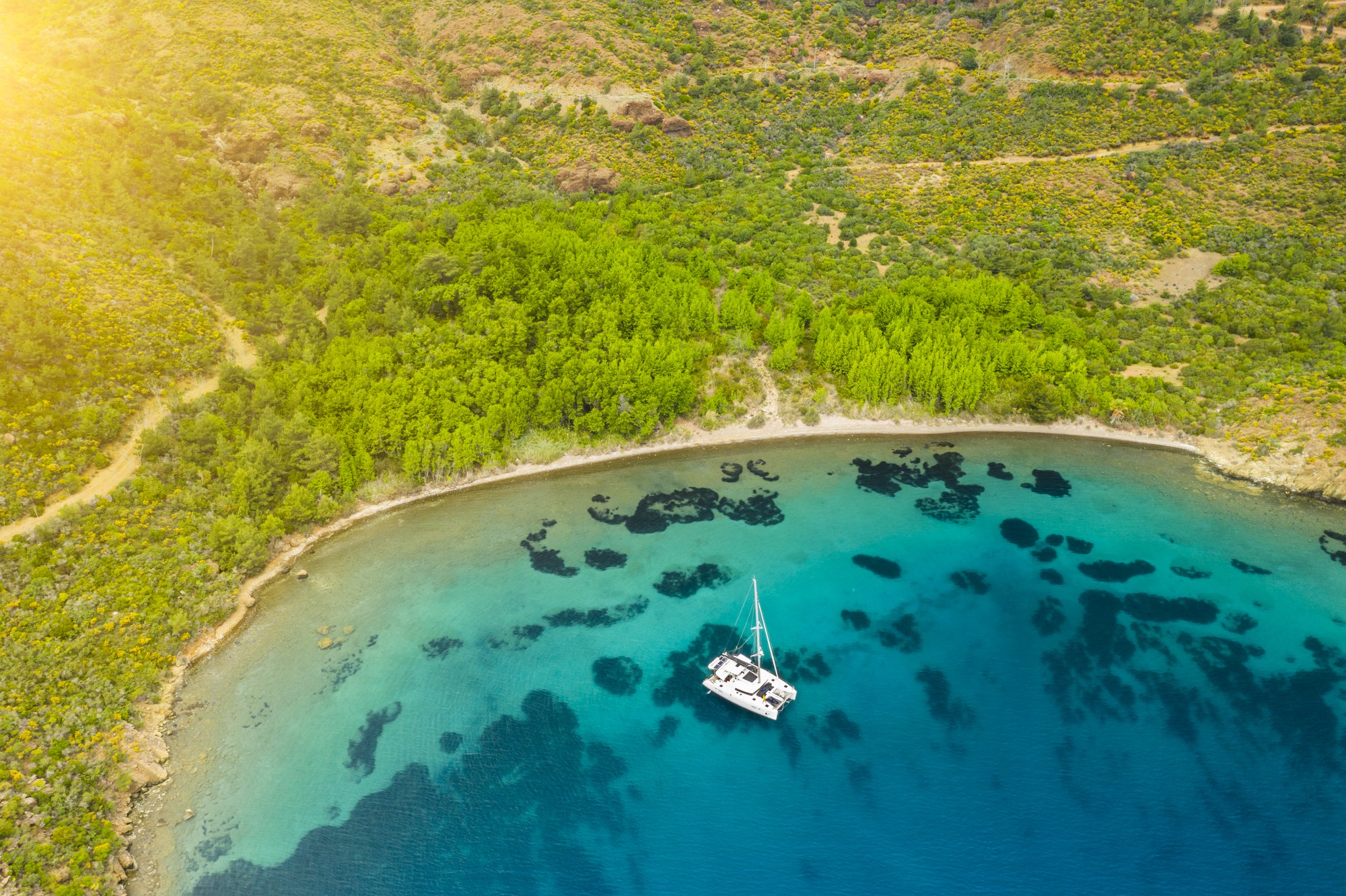 Aerial view of a catamaran yacht in the blue sea. Yachting, luxury vacation at sea