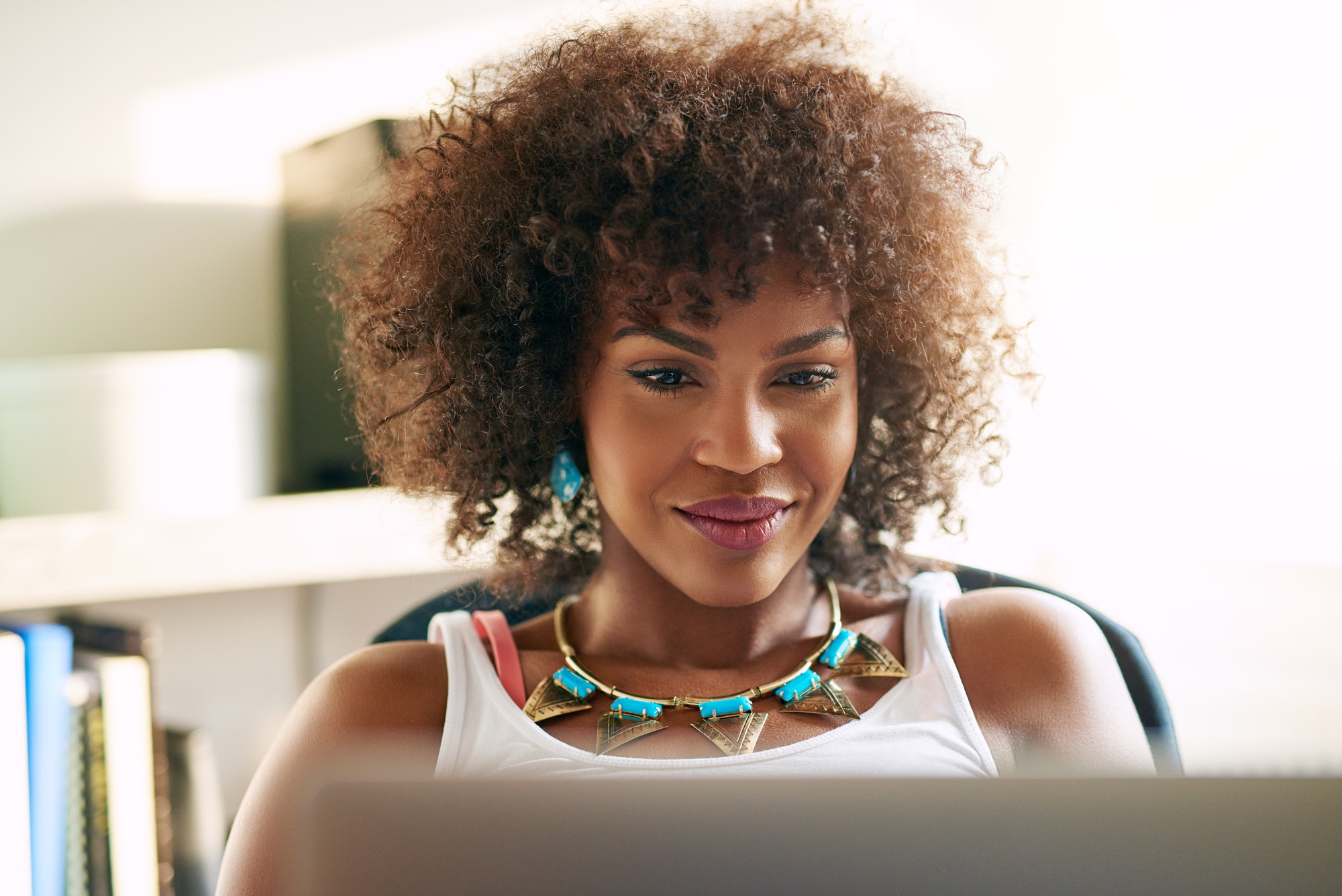 Good-looking black girl looking at desk-top