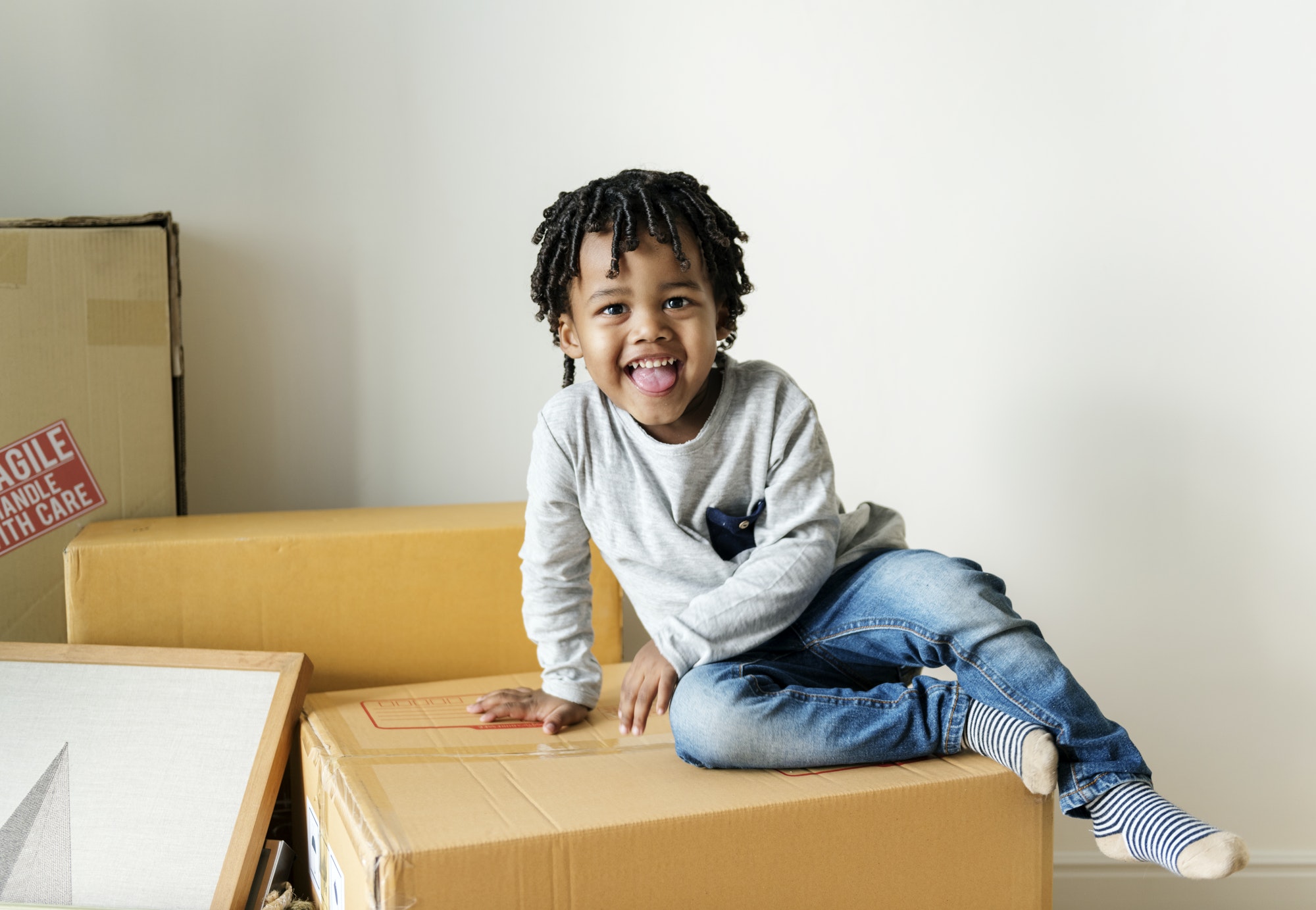 Young cheerful black boy moving to new house